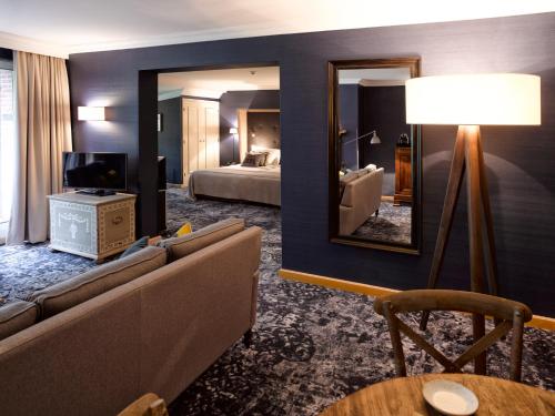 a living room with a couch and a mirror at Landgoed De Holtweijde in Lattrop
