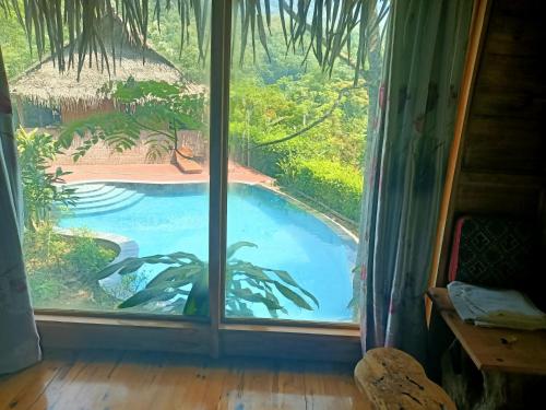 a window with a view of a swimming pool outside at Puluong homestay1holiday in Pu Luong