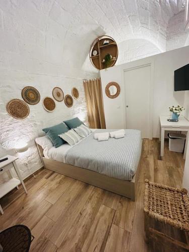 a bedroom with a bed in a room with a table at Biancomare - Casetta sul Mare in Polignano a Mare