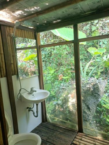 a bathroom with a toilet and a sink and a window at Puluong homestay1holiday in Pu Luong