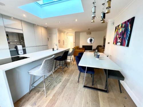 uma cozinha e sala de jantar com mesa e cadeiras em Comfortable 3 Bedroom House with Garden and Parking – Sleeps up to 6 em Catford