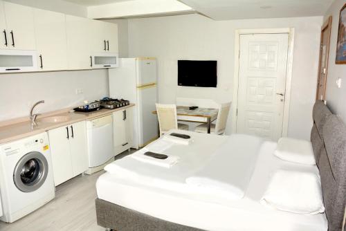 una cucina bianca con lavandino e tavolo di palmiye suıt otel a Istanbul