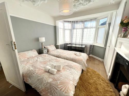 two twin beds in a room with a fireplace at Comfortable 3 Bedroom House with Garden and Parking – Sleeps up to 6 in Catford