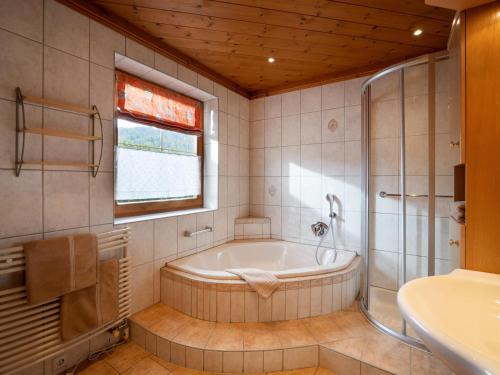 y baño con bañera, ducha y lavamanos. en Ferienwohnung Stock, en Kirchdorf in Tirol