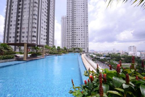 uma piscina no meio de dois edifícios altos em Nhaanhouse Sunrise City em Ho Chi Minh