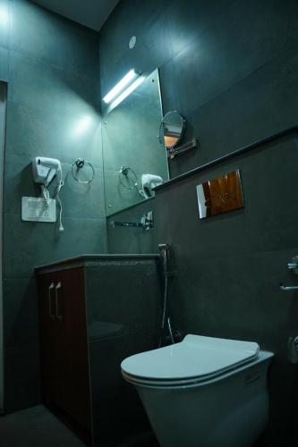 a bathroom with a toilet and a sink and a mirror at The Periwinkle Homestay Bhimtal in Bhīm Tāl