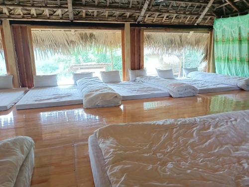 a room with four beds on a wooden floor at Puluong homestay1holiday in Pu Luong