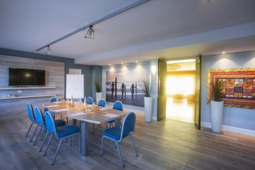 a dining room with a table and blue chairs at Grand Hotel Continental in Tirrenia