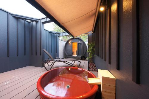 a tub on the deck of a house at Meitei no Yado Hotel Koshien in Fuefuki