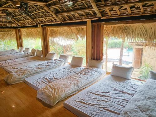 uma fila de camas num quarto com janelas em Puluong homestay1holiday em Pu Luong