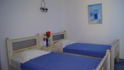 - 2 lits dans une chambre avec des draps bleus dans l'établissement Ethereal Apartments, à Agrari