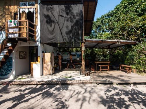 un edificio con un patio con una mesa y un banco en Cacimba Caraíva en Caraíva