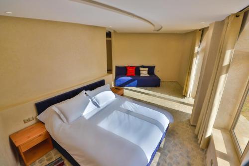 a bedroom with a white bed and a blue bed sidx sidx sidx at Bhalil Farm House in Sefrou