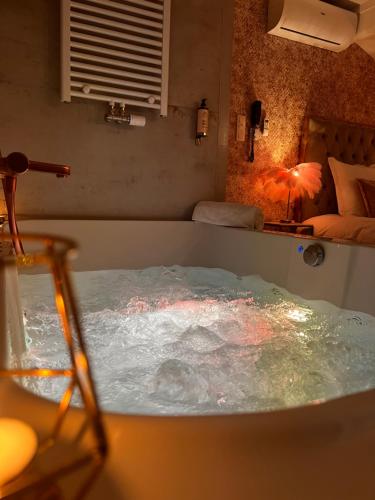 a bath tub filled with water in a room at Hôtel Mademoiselle in Liège