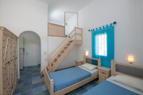 - une chambre avec 2 lits et un escalier dans l'établissement Ethereal Apartments, à Agrari