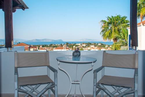 two chairs and a glass table on a balcony at 7 Islands in Spetses