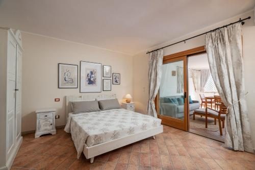 a bedroom with a bed and a sliding glass door at Sweet Mavy Incantevole Dimora by Wonderful Italy in Porto Rotondo