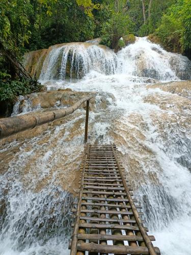 a waterfall with a wooden bridge in front of a river at Puluong homestay1holiday in Pu Luong