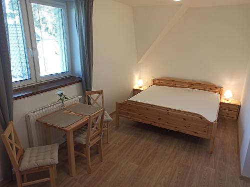 een slaapkamer met een bed en een tafel en stoelen bij Penzion U Vody in Horní Bečva