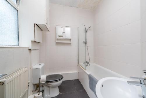 a white bathroom with a toilet and a sink at Soho Apartment Sleeps 4, Covent Garden & Leicester Square in London