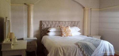 a bedroom with a bed with a zebra pillow on it at Capital On French Guest House in Pietermaritzburg