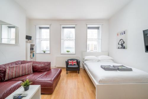 a living room with a bed and a couch at Soho Apartment Sleeps 4, Covent Garden & Leicester Square in London