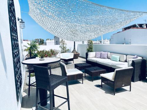 a patio with a couch and a table and chairs at Hostal Alisol Boutique San Pedro in Marbella