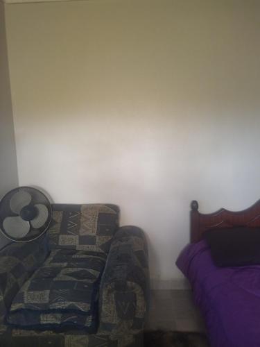 a bedroom with a couch next to a bed at Airbnb in Nakuru