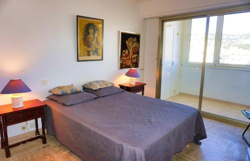 une chambre avec un lit et deux lampes et une fenêtre dans l'établissement Ref BEA - Palmes d'Or Properties, à Cannes