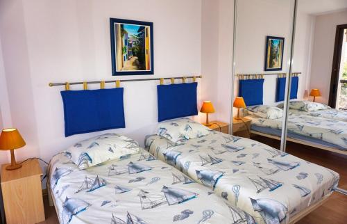 deux lits dans une chambre avec du bleu et du blanc dans l'établissement Ref BEAUSITE - Palmes d'Or Properties, à Cannes