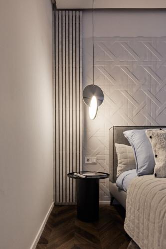 a bedroom with a bed and a table with a lamp at The Amberlyn Suite Hotel in Budapest