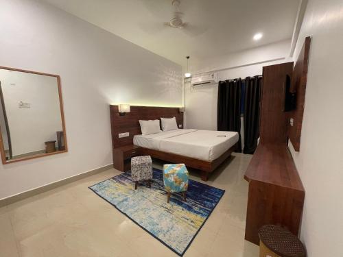a bedroom with a bed and a mirror and a chair at Yellow Sky in Baga
