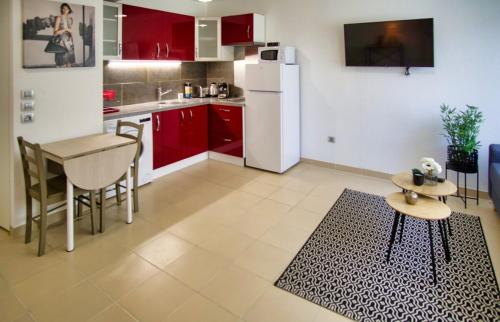 une cuisine avec des armoires rouges et un réfrigérateur blanc dans l'établissement Cannes charmant studio dans résidence moderne, à Cannes