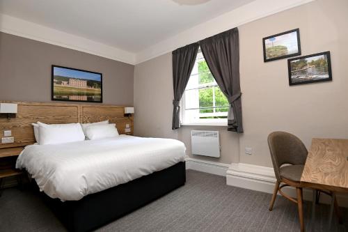 a bedroom with a bed and a desk and a window at Wheatsheaf, Baslow by Marston's Inns in Baslow