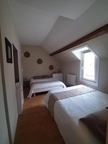 - une chambre mansardée avec 2 lits et une fenêtre dans l'établissement Libération classé 3 étoiles, à Grandcamp-Maisy