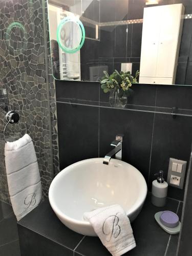 une salle de bain avec un lavabo blanc et un miroir dans l'établissement LA FONTAINE AP4355 By Riviera Holiday Homes, à Villefranche-sur-Mer