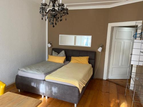 a bed in a bedroom with a chandelier at Pension Eichler in Löbau