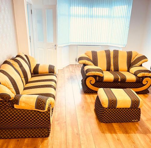 two chairs and two couches in a living room at Charming 3-Bed holiday House in Birmingham in Birmingham