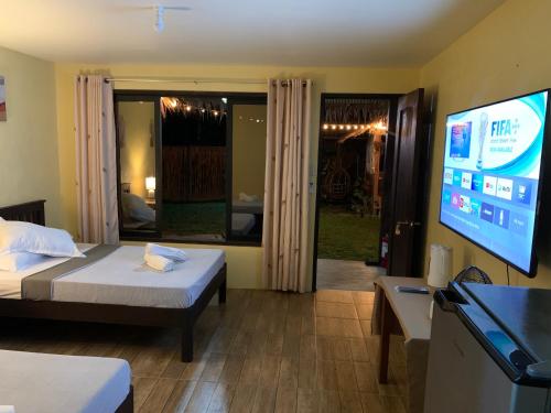 a hotel room with a bed and a flat screen tv at Onur Inn in El Nido