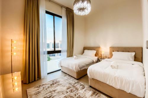 sypialnia z 2 łóżkami i dużym oknem w obiekcie Luxury Villas with Beach Access by VB Homes w mieście Ras al-Chajma