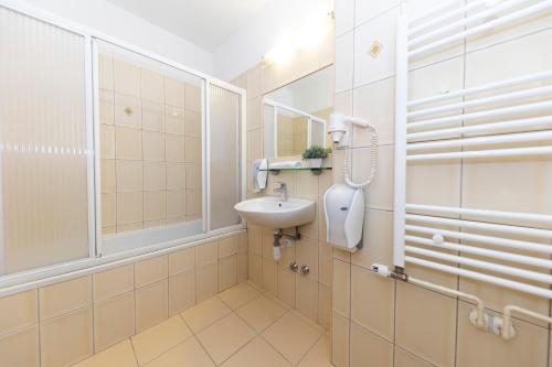 uma casa de banho com um lavatório e um chuveiro em Guesthouse Villa Irena em Zadar