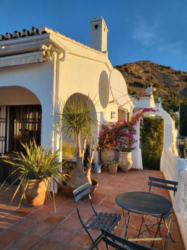 Un patio con una mesa y sillas frente a un edificio. en Romantic white Villa -private pool, en Nerja