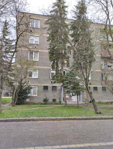 a large apartment building with trees in front of it at Love Lair Apartman in Miskolc