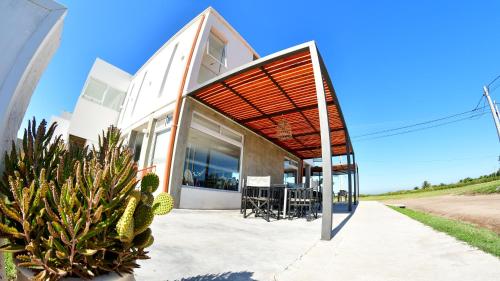 a modern house with a wooden pergola at Roseus Hotel Boutique in Miramar