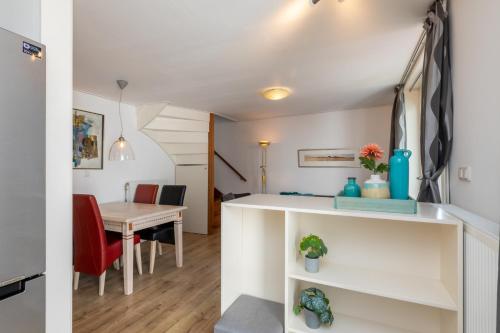 een keuken en eetkamer met een tafel en stoelen bij Welcome in - Knusse vakantiewoning met zonnig terras in het gezellige Domburg in Domburg