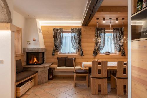 a dining room with a table and a fireplace at Casera Moda Luxury Chalet in Chies dʼAlpago