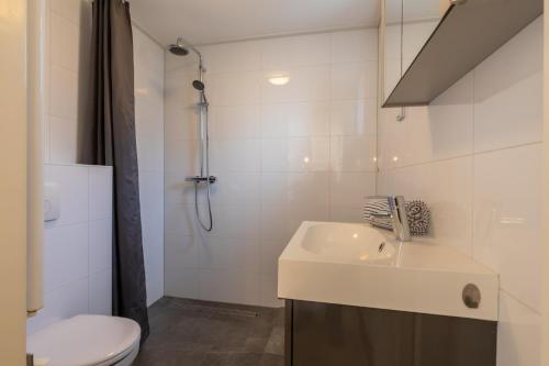 een badkamer met wastafel, douche en toilet bij Welcome in - Knusse vakantiewoning met zonnig terras in het gezellige Domburg in Domburg