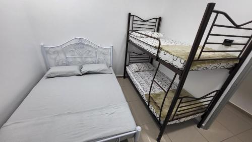 Cette petite chambre comprend 2 lits superposés et un banc. dans l'établissement Sri MaLati Homestay and Event Space, à Balik Pulau