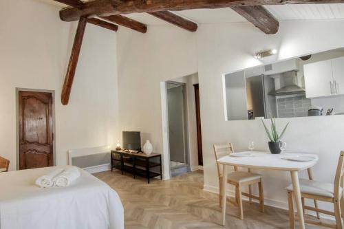 Cette chambre comprend un lit, une table et une cuisine. dans l'établissement Noa - Mont Piete Studio intramuros -, à Avignon
