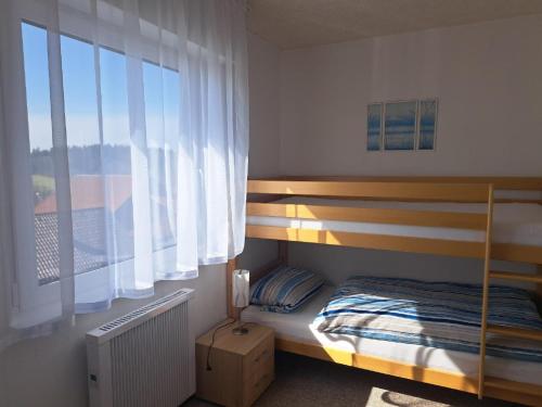 - une chambre avec des lits superposés et une fenêtre dans l'établissement Alpenblick, à Eppenschlag